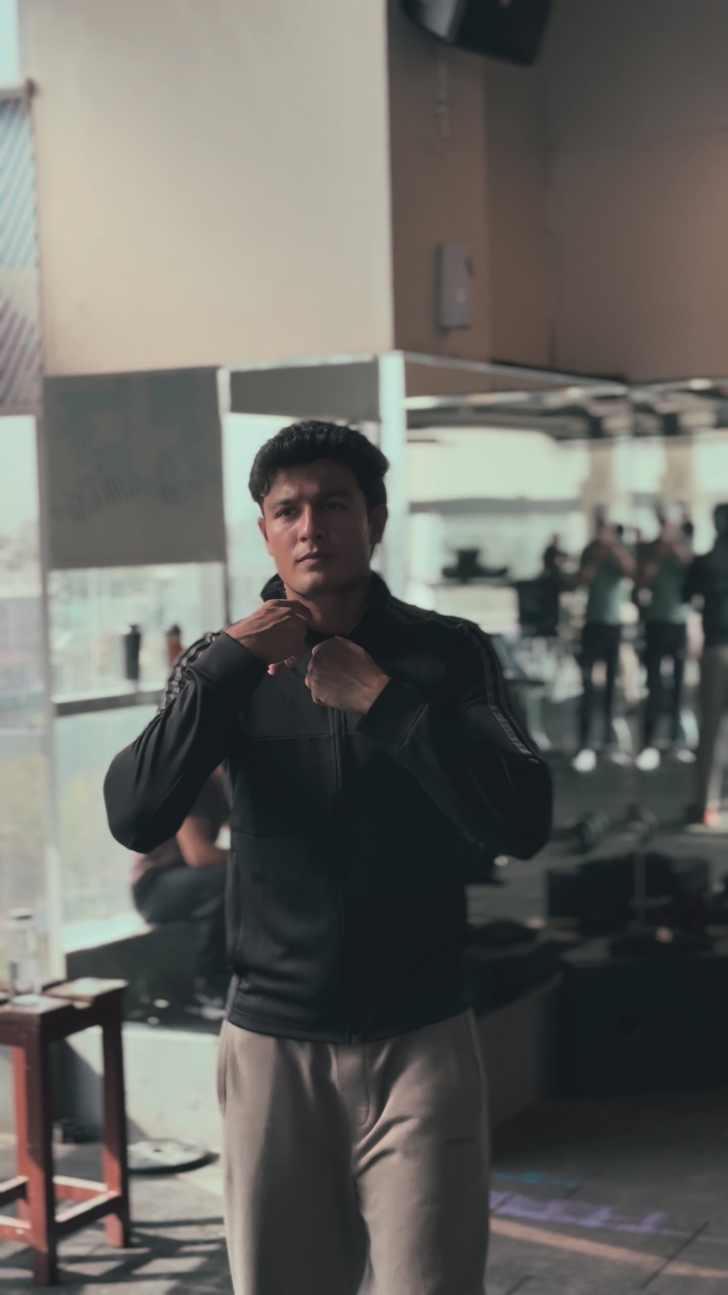 Load video: Man wearing a fitted compression T-shirt, showcasing the stretch fabric, athletic fit, and sweat-wicking design while posing and moving during a workout in a gym setting.